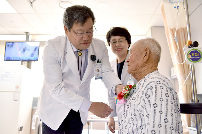 ‘어버이날’을 앞두고 화순전남대병원 정신 원장과 김광숙 간호부장이 고령 환자들의 쾌유를 기원하며, 카네이션을 선물하고 있다.