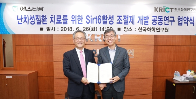 (왼쪽)에스티팜 김경진 사장과 (오른쪽)한국화학연구원 김성수 원장이 공동연구 협약 체결 직후 기념촬영을 하고 있다.