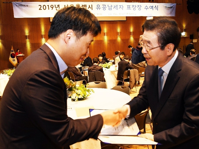 한미약품 이재형 회계팀장(左)이 박원순 서울시장(右)에게 모범∙유공납세 표창을 받고있다.