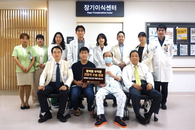 혈액형 부적합 간이식 수술 환자인 김종인씨(앞줄 가운데)가 퇴원에 앞서 부천성모병원 간이식팀과 부천성모병원 장기이식센터 앞에서 기념촬영을 하고 있다. 김종인씨(63세, 혈액형 O형+)는 특전사로 복무 중이던 아들 김정효(20세, 혈액형 A+)씨에게 간을 기증받아 6월 2일 수술하고 2주만인 6월 18일 건강히 퇴원했다.