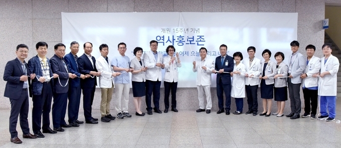 정신 원장을 비롯한 화순전남대학교병원 보직자들이 최근 원내 1층 벽면에 6m길이의 영상 디스플레이를 갖춘 ‘역사홍보존’을 개설하고, 기념촬영.