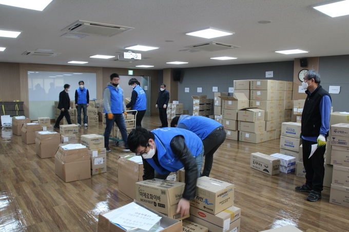 13일 서울 서초구 방배동 한국제약바이오협회 2층 오픈이노베이션플라자에서 협회 임직원과 동아제약 CSR팀이 대구·경북 등 5개 지역에 지원하기 위한 ‘제약바이오기업 코로나19 긴급 구호품’을 옮기고 있다.