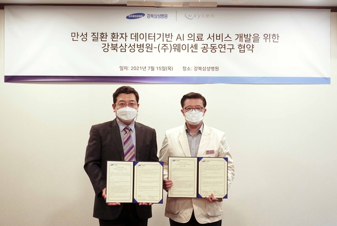 좌부터 ㈜웨이센 김경남 대표이사, 강북삼성병원 미래헬스케어 강재헌 추진단장이 공동연구 협약서를 함께 들고 포즈를 취하고 있다.