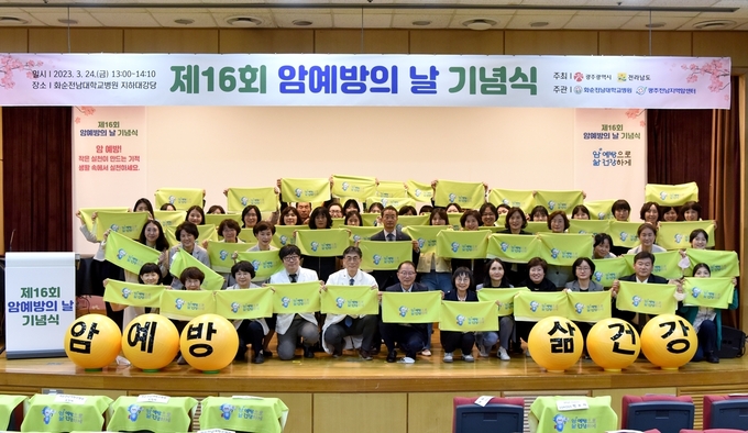 화순전남대학교병원 광주전남지역암센터가 개최한 ‘제16회 암 예방의 날 기념식’에서 참석자들이 ‘암 예방으로, 삶 건강하게’ 문구가 적힌 스카프를 들고 기념 촬영을 하고 있다