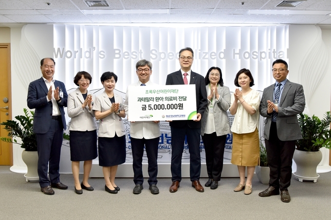 화순전남대병원 정용연 병원장(왼쪽에서 네 번째)와 초록우산어린이재단 전남지역본부 김유성 본부장(오른쪽에서 네 번째) 등이 과테말라 희소병 환아를 돕기 위한 의료비 전달식을 마치고 기념 촬영을 하고 있다.
