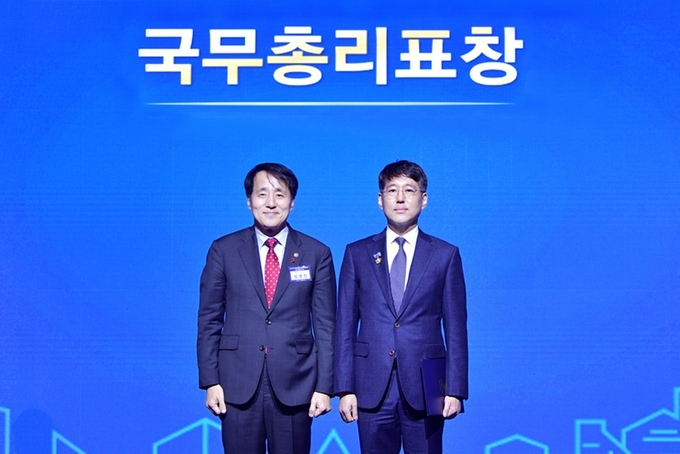 한미약품 자율준수관리자 김현수 컴플라이언스팀 상무(우)가 한덕수 국무총리를 대신한 장영진 산업통상자원부 제1차관으로부터 표창장을 받은 후 기념 촬영을 하고 있다.