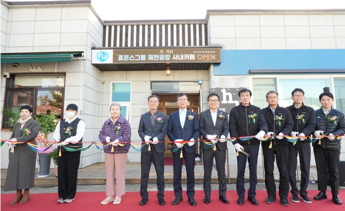 휴온스가 지난 10일 제천공장에서 ‘장애인 바리스타 카페’ 문을 열었다.지역사회 연계 사회공헌이 돋보이는 대목이다.이날 행사에는 휴온스 그룹 윤성태회장(우에서 6번째)을. 비롯 임직원 및 지역 주민이 참석해 축하했다.